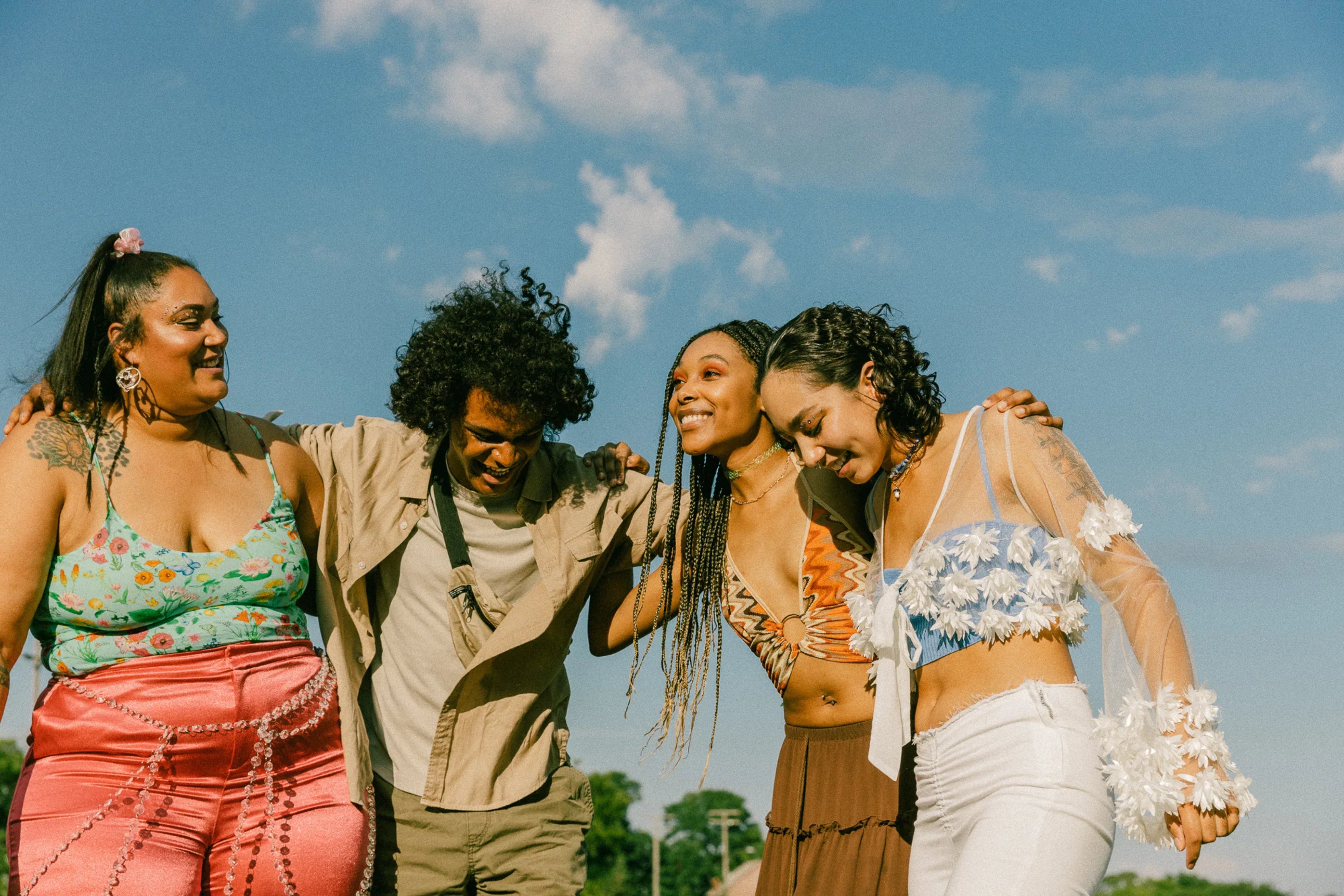 Four people standing together with a clear blue sky in the background